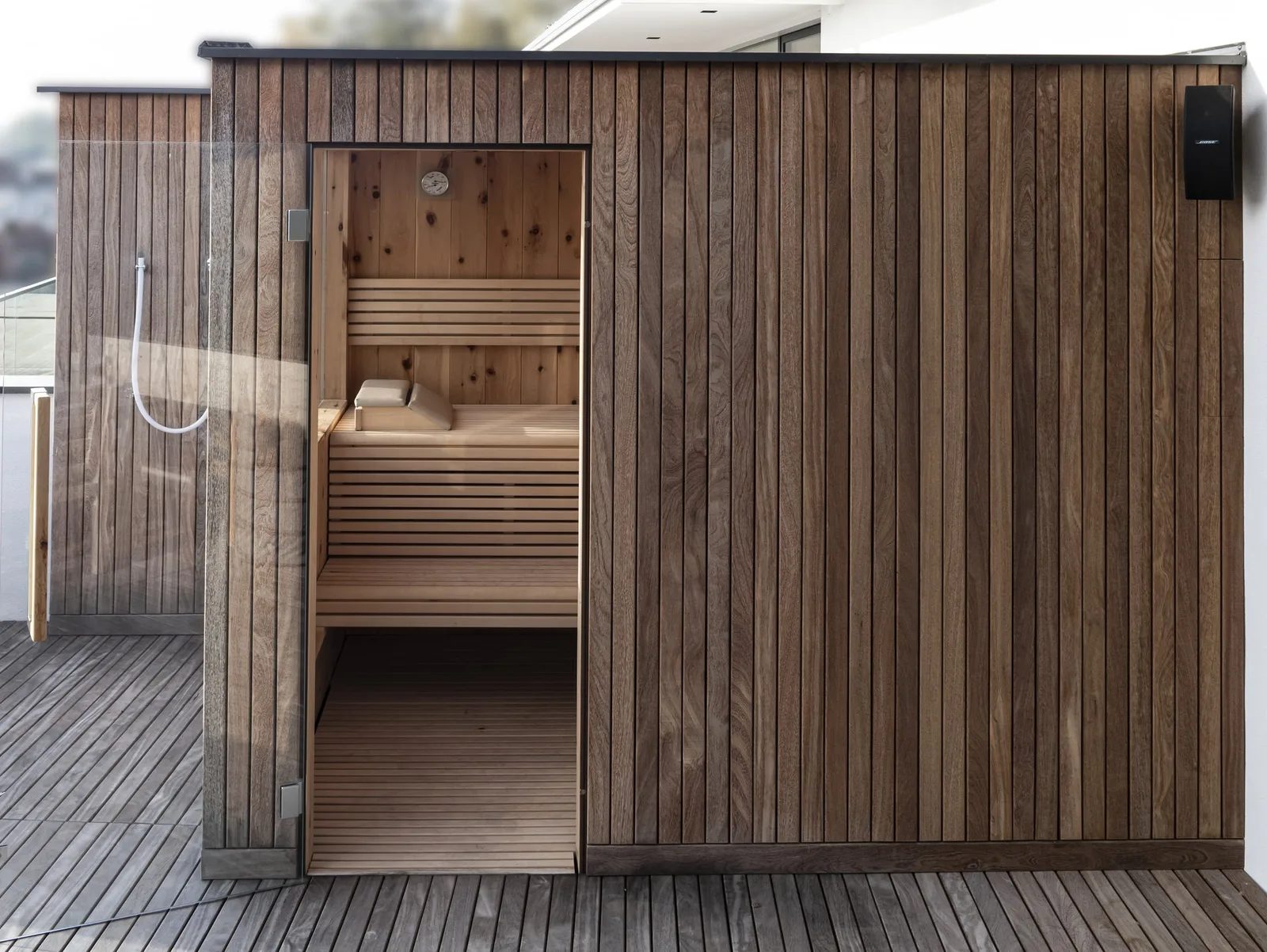 Außensauna aus Holz mit Glastür auf einer Dachterrasse