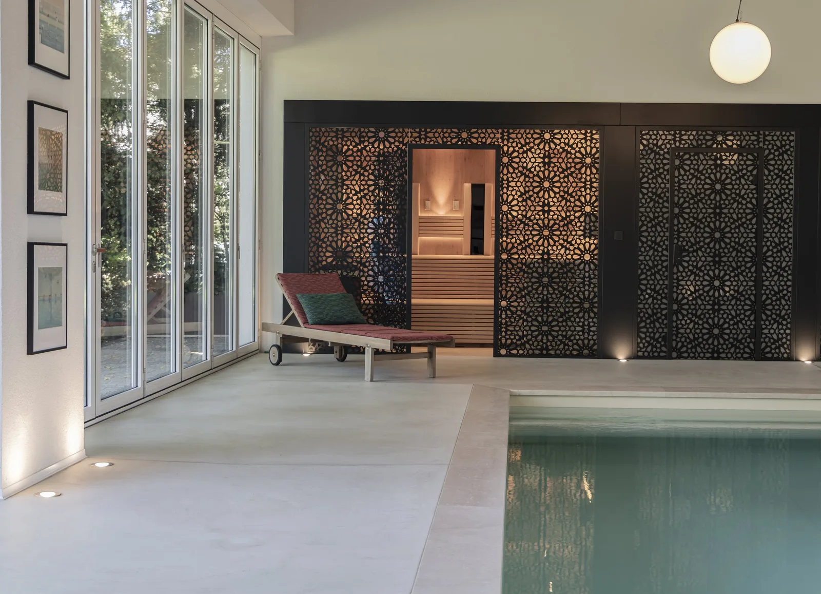 Wellnessraum mit Pool, die Sauna hinter einer Wand mit Ornamentmuster