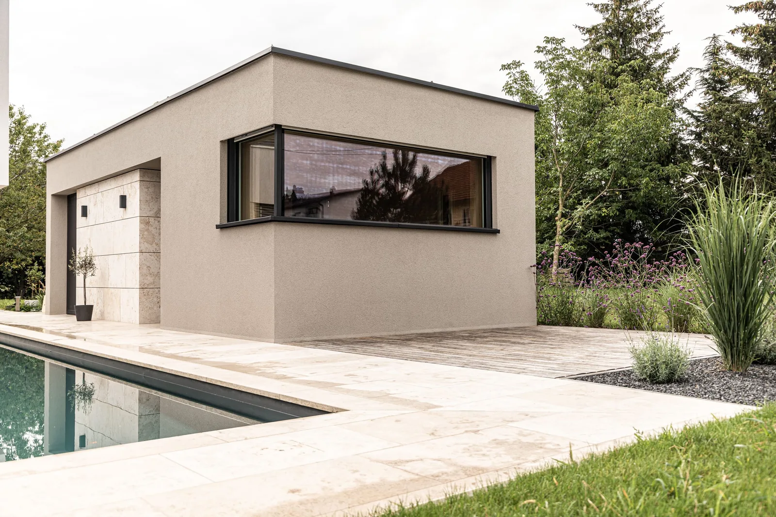 Poolhaus mit heller Holzterrasse am Pool